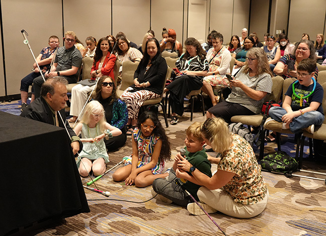 President Riccobono sits on the floor with a group of blind kids for a chat at the NOPBC seminar.